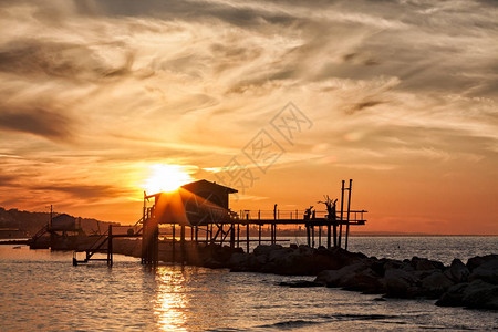 安科纳在的夕阳下海上的高跷房子在背光下背景