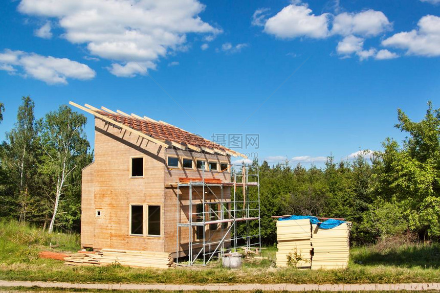 在生态房屋中建造木屋顶建筑围护结构的外部工作森林附近图片