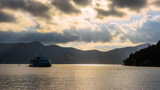 看到船在Ashi湖与Hakone神庙红色托里伊门对着日落图片