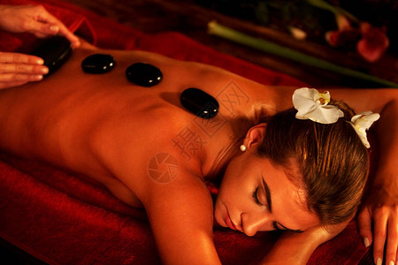 热石疗法包按摩spa沙龙的女人石头背景图片