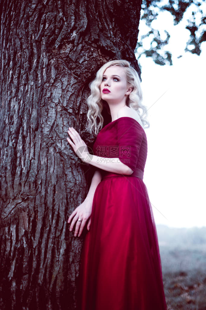 在童话般的森林里穿着漂亮的红色连衣裙图片