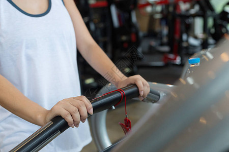 在健身房锻炼运动俱乐部中心在跑步机心肺机上慢跑和步的特写手女人图片
