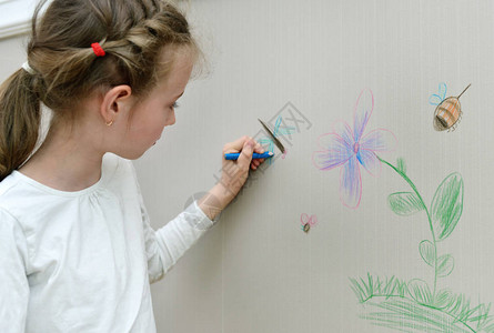 小女孩用铅笔在墙纸上画背景图片