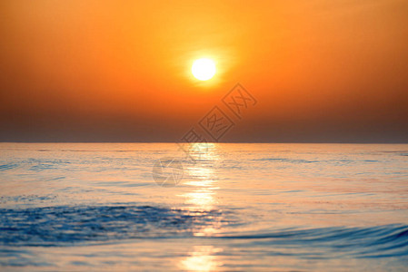 日落或日出在海面上与大太阳相照在美丽的背景图片