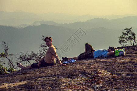一群游客在山顶看日落爬山后休息图片