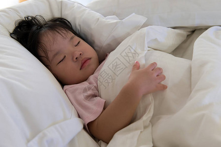 亚洲小孩睡在床上的特写镜头图片