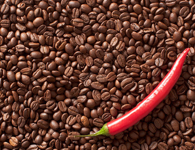 在咖啡豆背景的辣椒背景图片