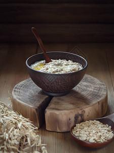 用黄油做燕麦在木上的粘土碗里做燕麦图片