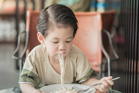 亚洲可爱的辣妹在餐厅吃意大利面条卡宝拉SpaghettiCarb图片