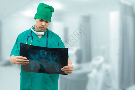 外科医生检查X光胶片诊断病人的腰骨图片