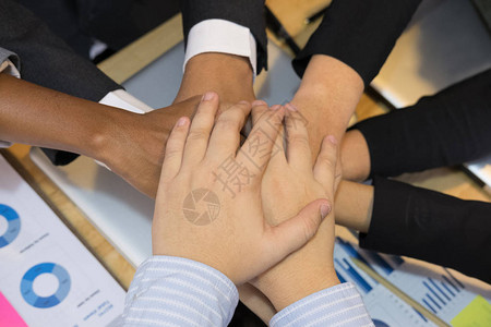 年轻的亚洲商人加入团结的手背景图片