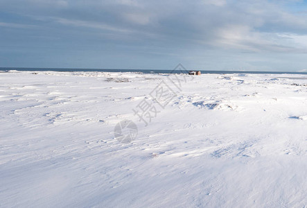 位于远处冰岛欧洲和冰岛的深雪覆盖地表景观上的建筑图片