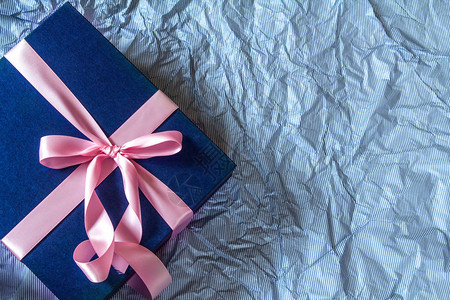 Polka蓝纸上带丝装饰的深蓝色礼品盒父亲节快乐或庆祝礼物概念顶视和俯冲拍摄右背景图片