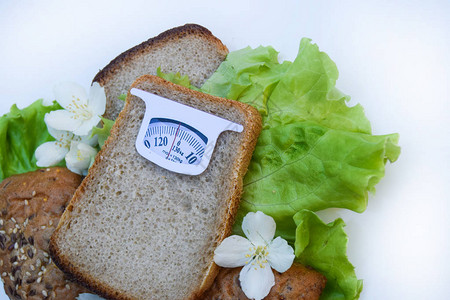 暴瘦符从在白色背景上隔离的一片面包的假想鳞片健康饮食和体重管理的饮食概背景