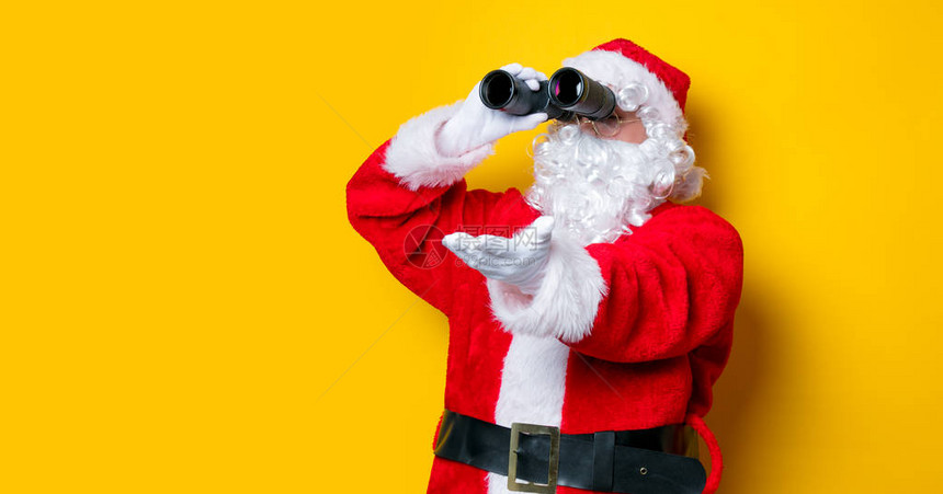 可笑的圣诞老人拿着黄色背景图片