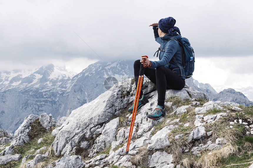 看着女登山者享受山上空中的空气图片