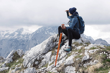 看着女登山者享受山上空中的空气图片