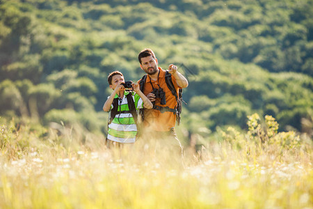 父亲和儿子夏天在自然中徒步旅行图片