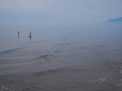 两个人在地平线上划桨登机图片
