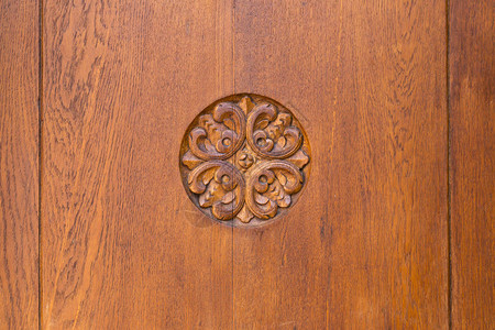 一扇棕色木门的特写上面有复杂的装饰雕刻图片