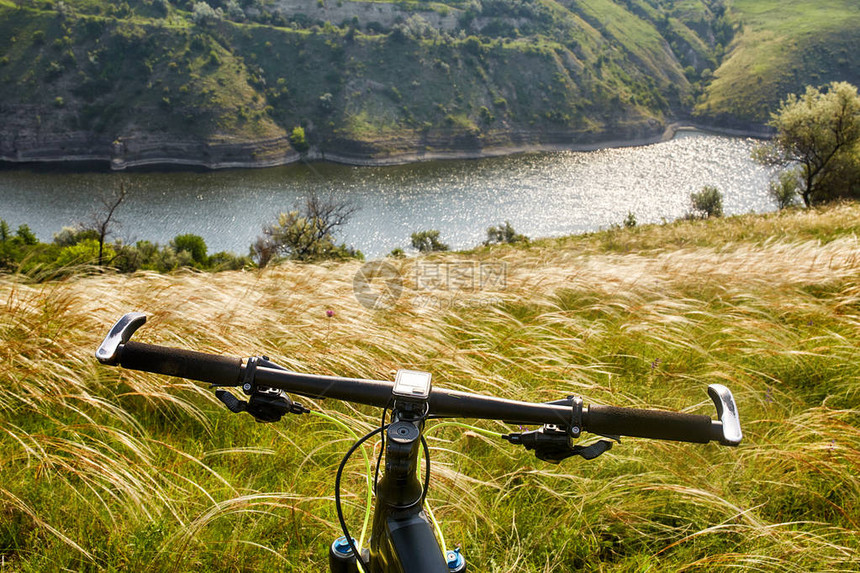 山地自行车细节的特写镜头在绿草的自行车的舵和轮子水平照片体育背景极端的乡村旅行图片