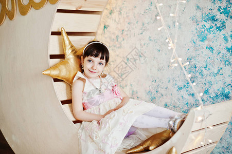 穿着裙子的漂亮小女孩穿着金星枕头在木月装图片