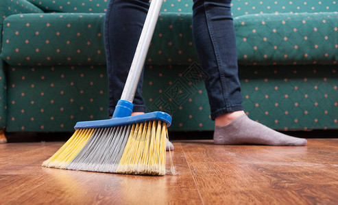 将清洁女工扫木制地板作为清洁家务工作概图片