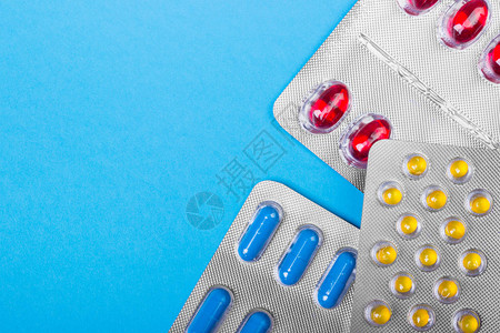 蓝色背景的彩色药丸药片和胶囊图片