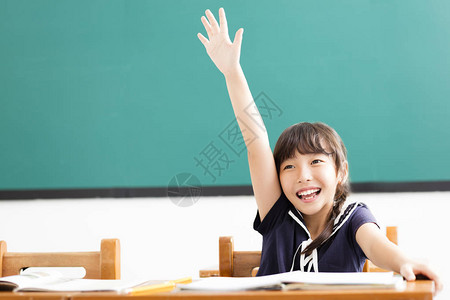 快乐的小女孩举起手在教室里图片