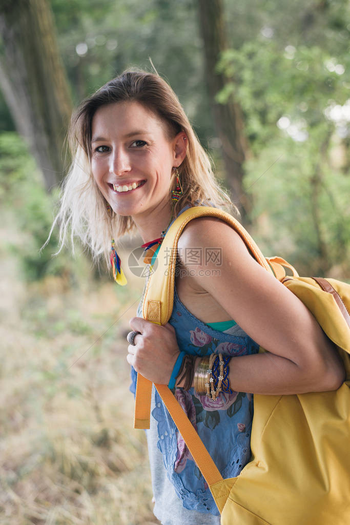 在森林里微笑的背包客女人图片