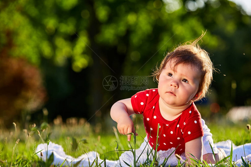 可爱的可爱漂亮宝贝女孩穿着红色的春装微笑着坐在树下婴儿坐在图片
