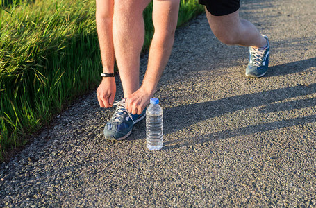 跑鞋赤脚跑鞋关闭男运动员系鞋带在路上慢跑赛跑者领带准备训练图片