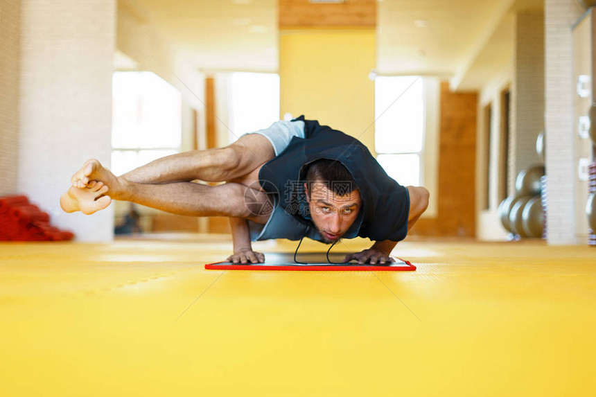 瑜伽做瑜伽的年轻人手站立姿势瑜伽大师在黄色健身房锻炼在室内做瑜伽的人图片