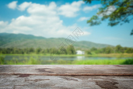 选中的空焦距旧木桌和蓝色天空或山地模糊背景图片