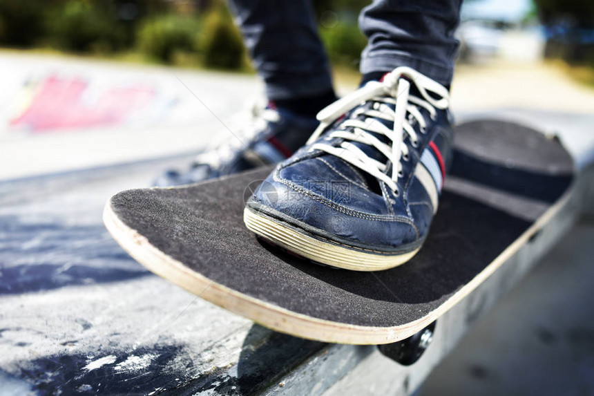 在户外滑板公园里玩滑板的一名年轻的天主教图片