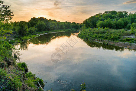 河流上日落绿树飞天乌云图片