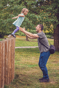 父亲抓住女儿从高的木杆上跳下图片