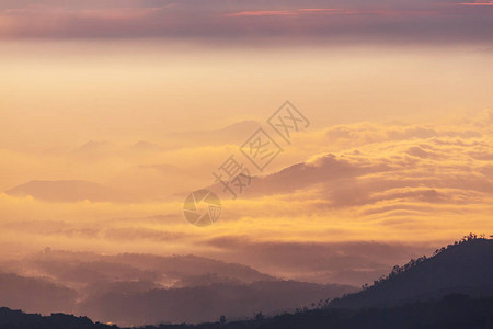 日落时云中的山剪影图片