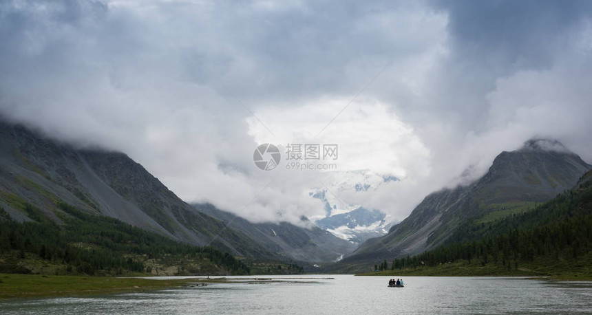 一群人乘橡皮船游过高山湖图片
