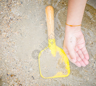 沙海水面上的儿童手和玩具铲图片