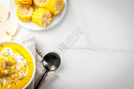 素食菜肴传统的秋季玉米汤配玉米棒子蔬菜奶油在一张白色的大理石桌子上复图片