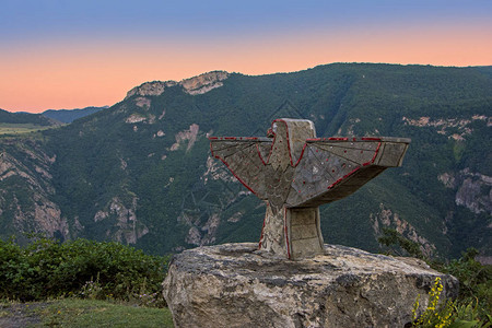 日落阳光照亮的沃罗坦河峡谷的一块大石头上的鹰雕塑图片