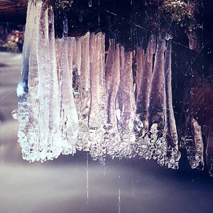 胶片颗粒效果有冰柱的冬天小河在冻结山涧之上在河流的冬季图片