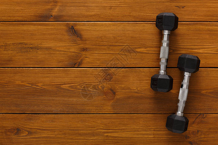 木制背景复制空间上的两个哑铃体重锻炼增图片