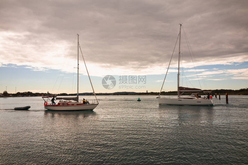 两艘帆船在斯旺西附近的麦夸里湖清澈宁静的水域相遇图片