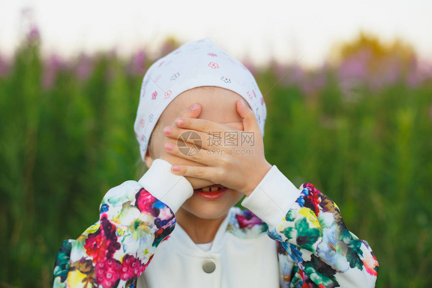 美丽的小女孩用双手遮住她的眼睛将图片