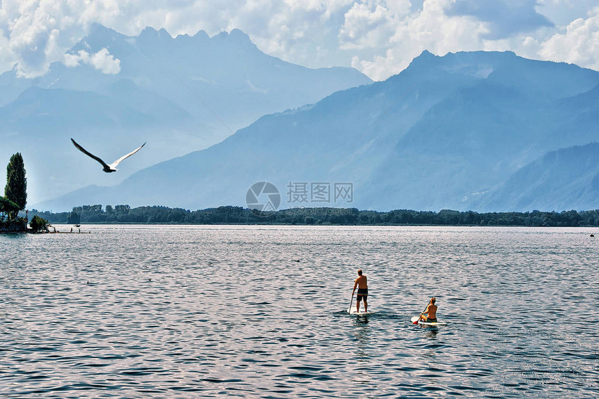 在瑞士沃州蒙特勒的日内瓦湖上站着一对夫妇在单板图片