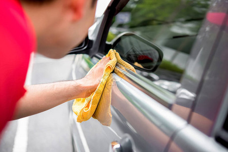 一名男子用微型纤维布清洗汽车自动详细描图片