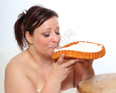 超重的女人吃甜奶油蛋糕肥胖的人享受生活健康的图片
