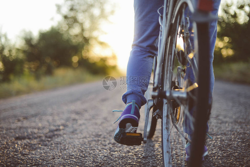 美丽的女孩在路上骑自行车户外健康和运动概念夕阳下骑图片